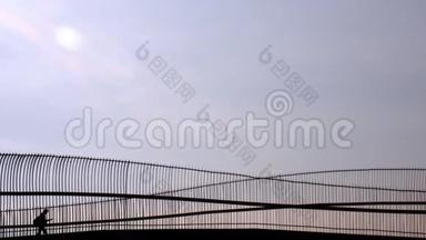 一个人通过水槽走过桥的剪影。